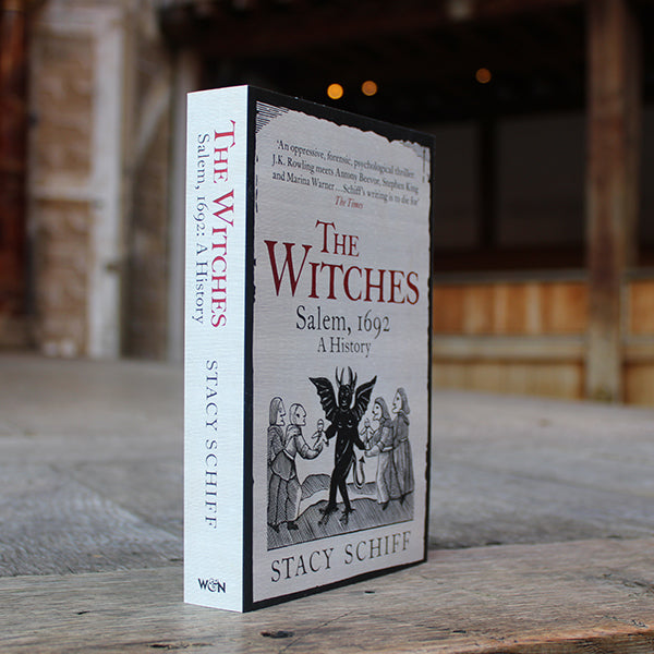 Off white paperback book with red and black text with black imagery, book at an angle