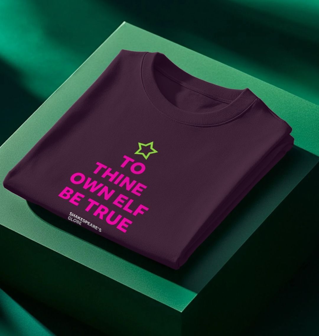 Folded purple sweatshirt with text and star design on a green surface