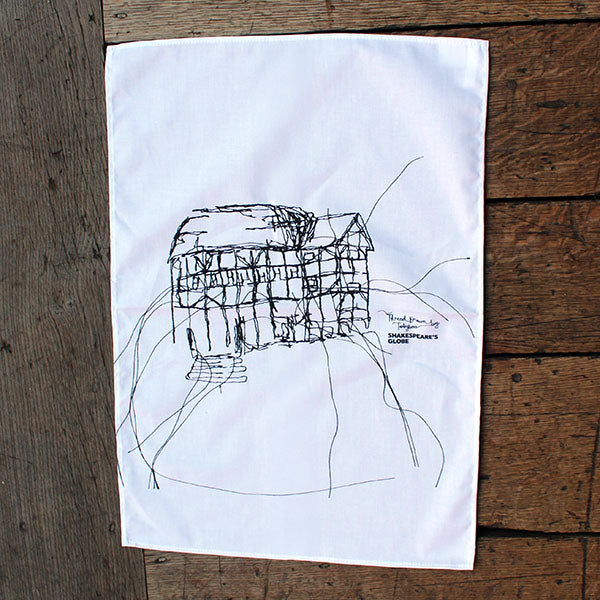 white tea towel with a black line drawing print on a wooden surface