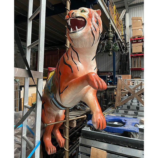 Life-sized prancing tiger statue with a gold carousel pole and saddle.