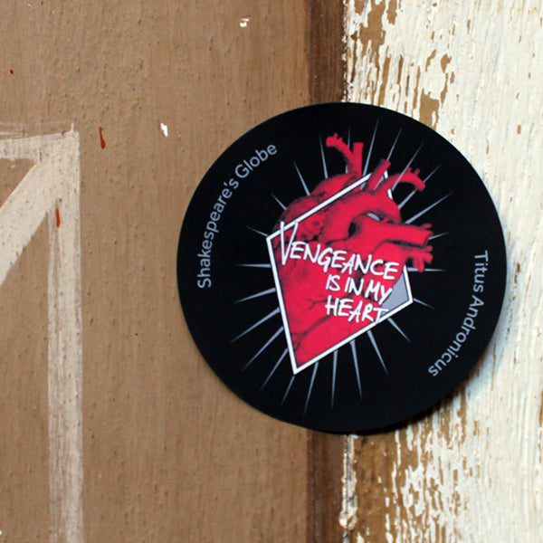 Black circular sticker with red anatomical heart graphic in the centre, with white graphic text