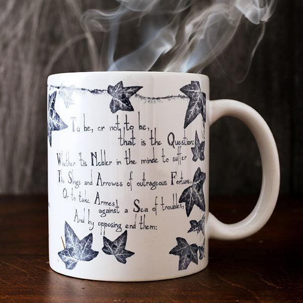 White mug with grey leafy graphics with scratchy 'to be' quotes text on either side