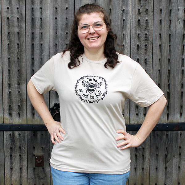 Oatmeal coloured classic fit t-shirt with central circular graphic of bumble bee with graphic black text and floral imagery around