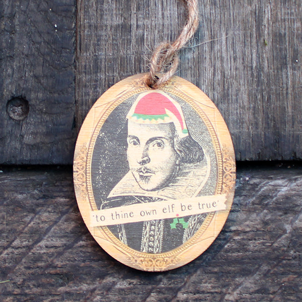 Wooden oval decoration with black portrait and cartoon red santa hat