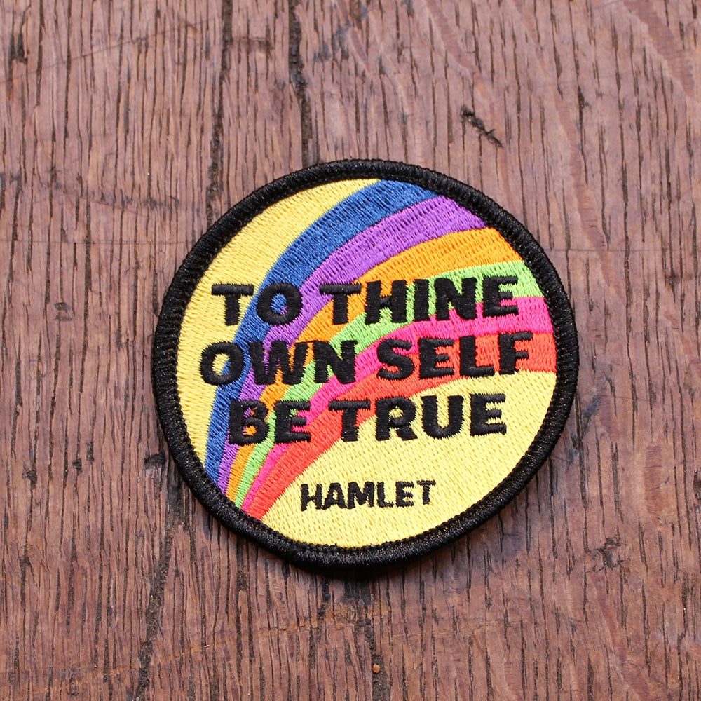 Rainbow yellow patch with black border and bold black text, circular shape