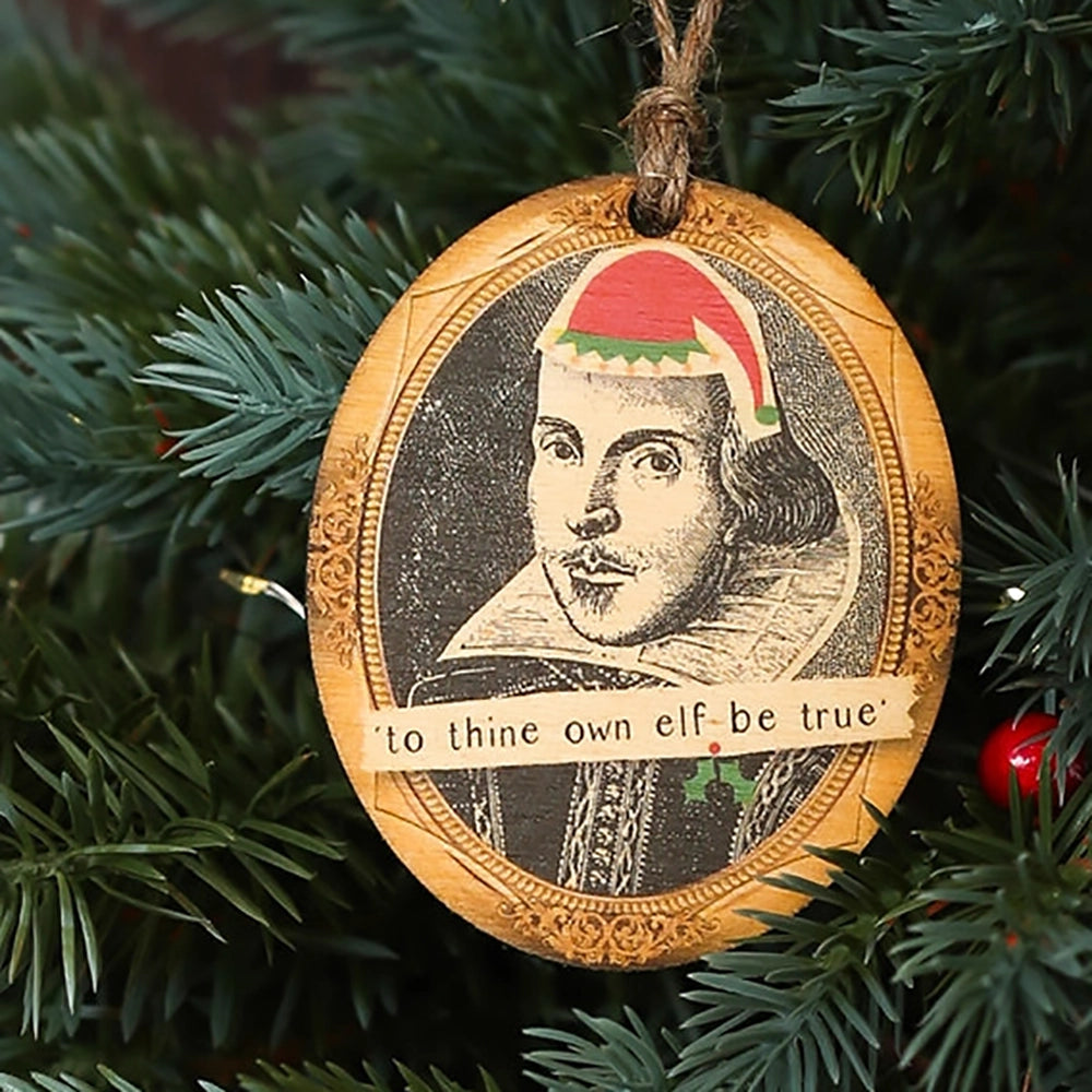 Wooden oval decoration with black portrait and cartoon red santa hat, on Christmas tree