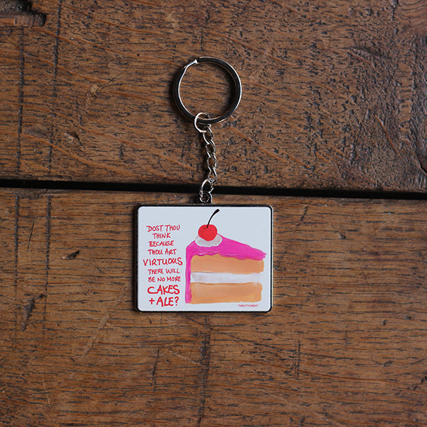Silver coloured metal keyring with flat portrait orientated image of a slice of cake with scratchy pink graphic text on a white background
