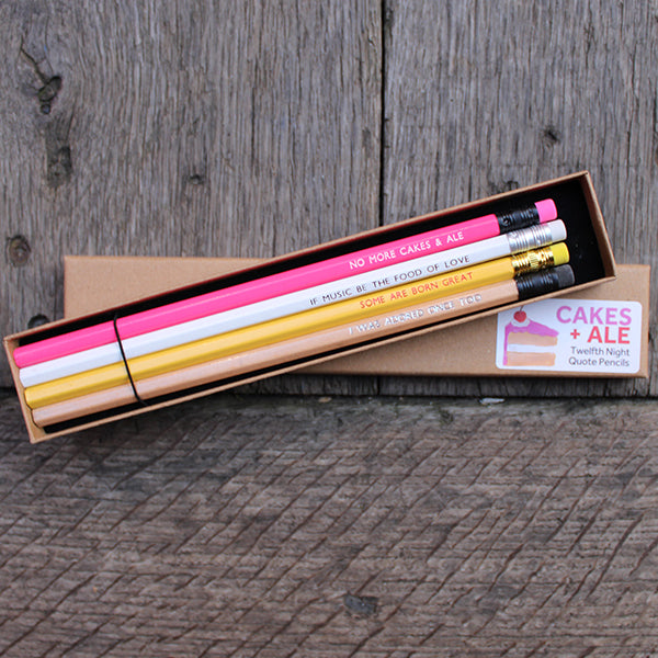 Four quote stamped pencils from top to bottom: pink, white, yellow, gold, sitting on a kraft box with white sticker
