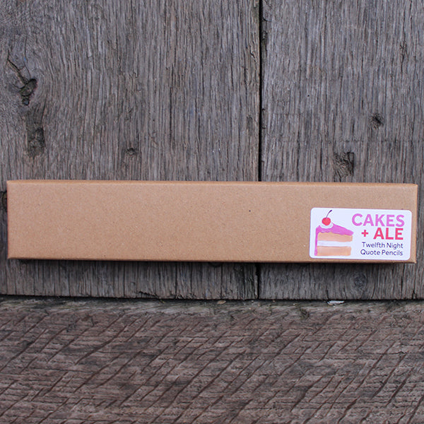 Long rectangular landscape orientated kraft box with white sticker in bottom right corner featuring cake graphic