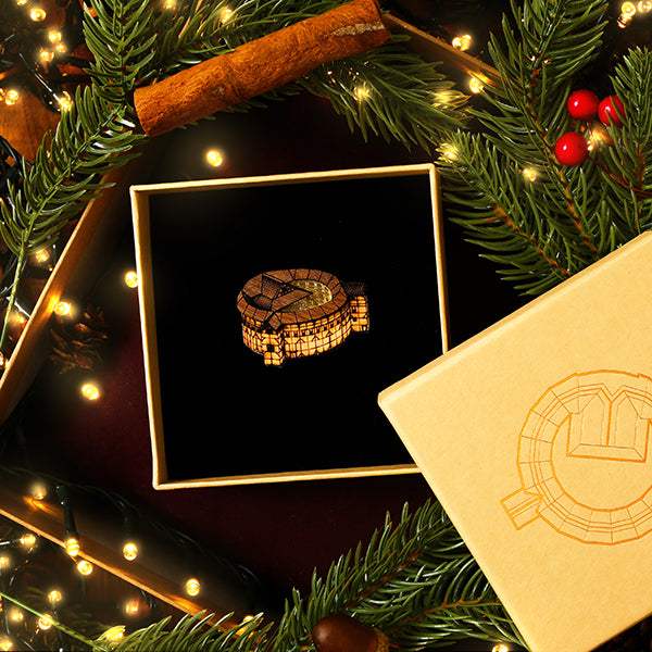 Decorative walnut brooch with Christmas decorations on a dark background