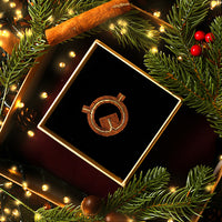 walnut wood brooch of the Globe Theatre in plan view in a gift box surrounded by festive greenery