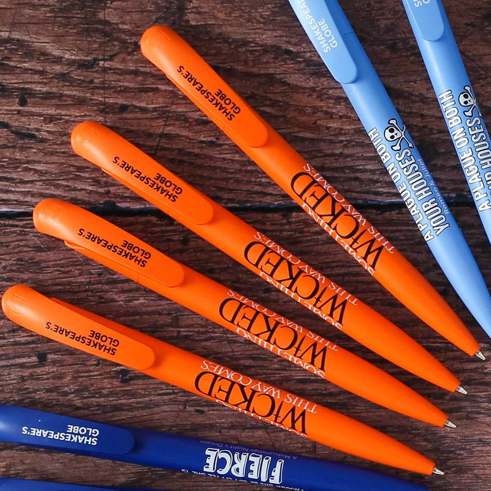 Orange bioplastic ballpoint pen printed on the barrel with a quote from Shakespeare play, Macbeth, "Something wicked this way comes", in black and white lettering