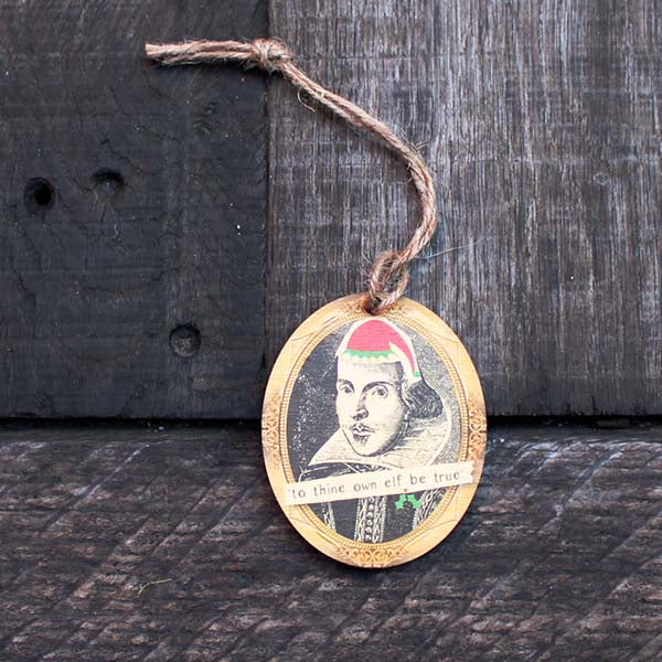 Wooden oval decoration with black portrait and cartoon red santa hat