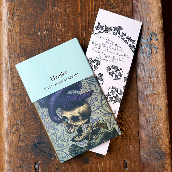 Large card bookmark with a white background, printed with a black and white image of a human skull on a bed of ivy leaves. A quote from Shakespeare play, Hamlet ,