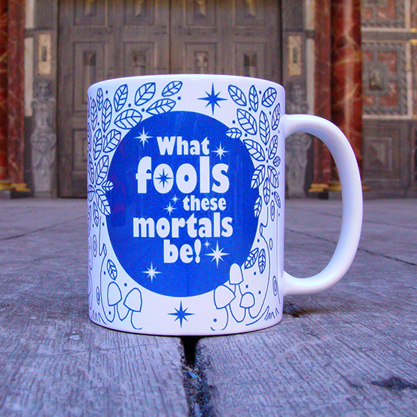 White earthenware coffee mug with a design printed in blue. The design consists of a solid blue circle representing the full moon, surrounded by hand-drawn leaves and mushrooms, to imitate a forest. In the centre of the moon is a quote from Shakespeare play, A Midsummer Night's Dream printed in white. The quote is surrounded by white stars