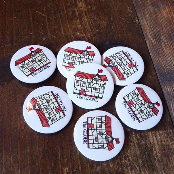 38mm round button badge with a cartoon image of the Globe Theatre printed on a white background. The cartoon Globe has a black frame, and a red roof, door and flag. The words 'The GLOBE' are printed beneath the image in black