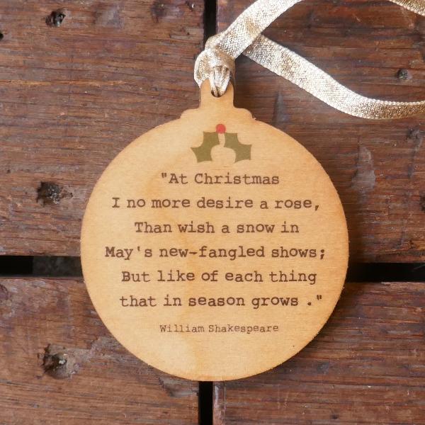 Round wooden Christmas decoration with etched William Shakespeare quote on it