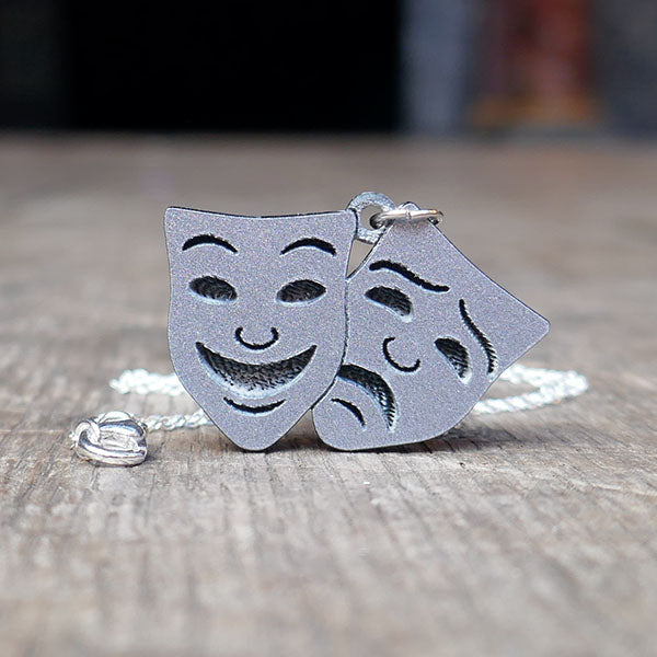 Comedy and Tragedy masks pendant made from silver sparkle acrylic on a silver chain.