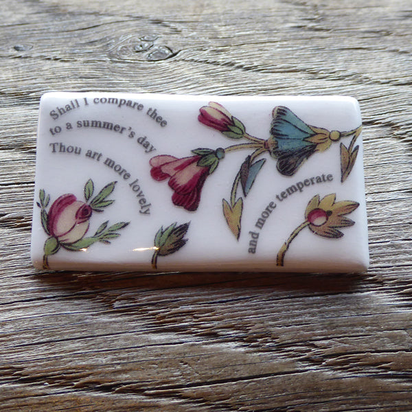 Rectangular ceramic brooch with lines from Shakespeare's Sonnet 18 and images of flowers