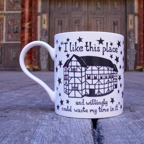 A white porcelain mug with a black and white illustration of the Globe Theatre and the quote 'I like this place' printed on it.