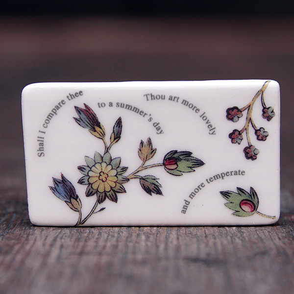 Rectangular ceramic brooch with lines from Shakespeare's Sonnet 18 and images of flowers