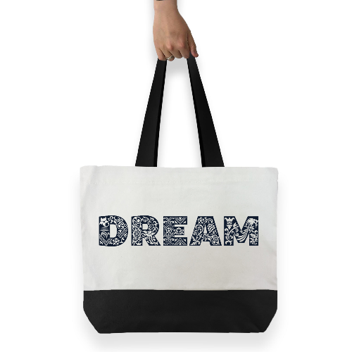 White cotton tote bag with black handles and black base featuring large black graphic text across the front DREAM