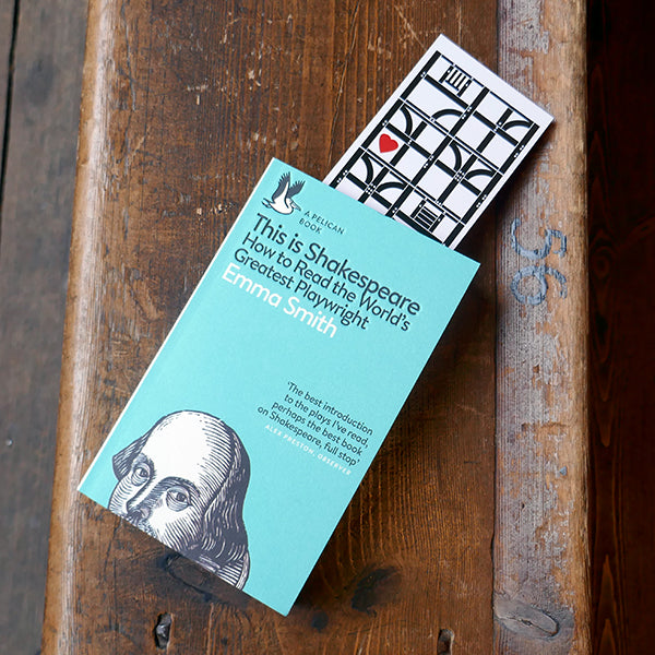 Large card bookmark with a white background, printed in black with representations of the architectural panels that make up the Globe Theatre's wooden frame. A bright red graphic heart sits inside two of the frames., Shown with a copy of 'This is Shakespeare' by Emma Smith