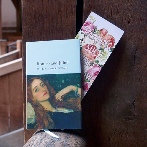 Large card bookmark with a white background, printed with a bouquet of summer flowers (roses) in pinks, creams and peaches. Over the flowers is printed a quote from Shakespeare play, Romeo & Juliet,