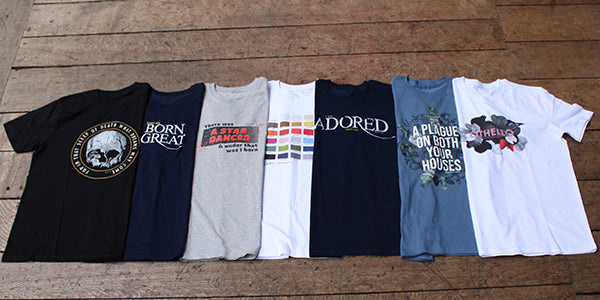 7 graphic t-shirts arranged in a line, folded lengthwise on top of one another