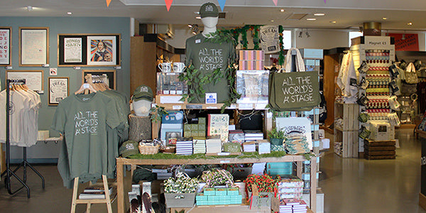 Interior of the Globe Shop with wooden table filled with 'As You Like It' themed gifts
