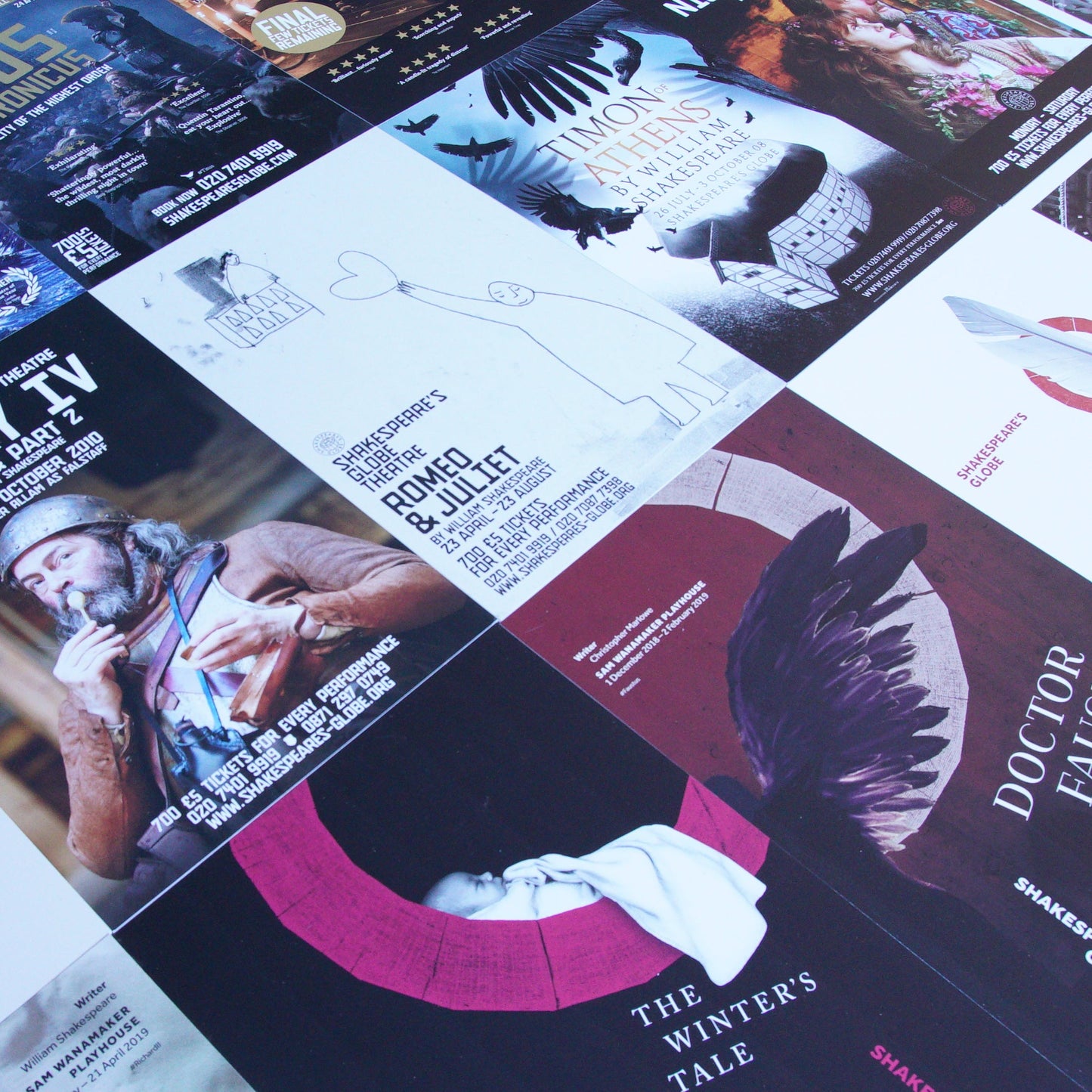 Angled image of portrait orientated play posters laying flat and side by side.