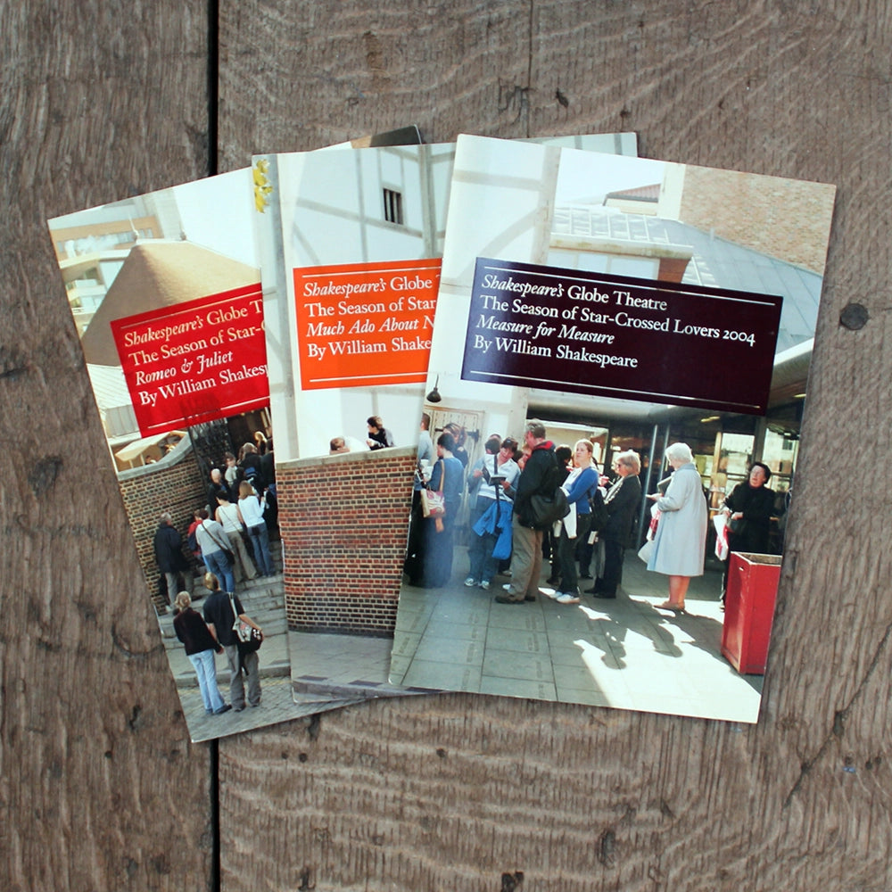 Three theatre programmes with photographic images on the covers on a wooden background