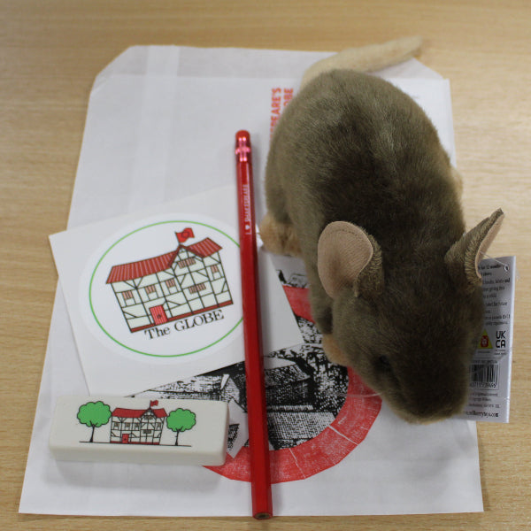 
                  
                    White paper bag with cartoon Globe sticker, red pencil, cartoon Globe eraser, and rat plush toy sitting on top
                  
                