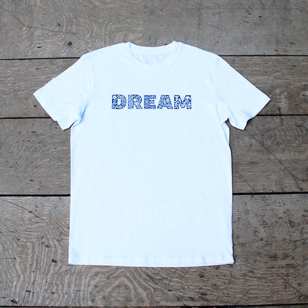 White t-shirt with patterned text across the chest in Blue that reads DREAM