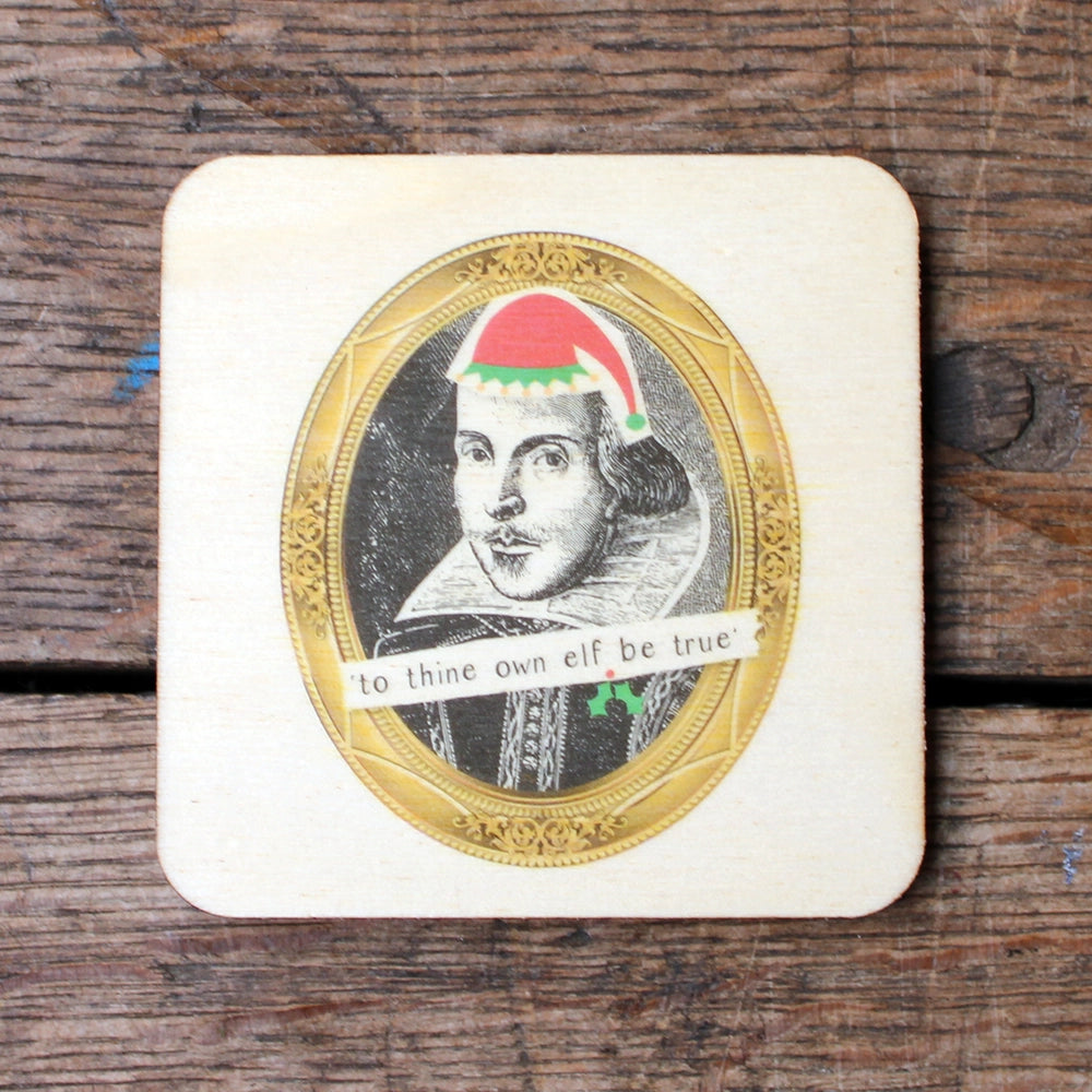 Light coloured wooden coaster with an image of Shakespeare in a red and green elf hat