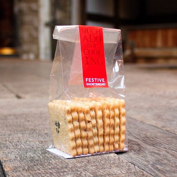 Packaged festive shortbread cookies with a red label on a wooden surface