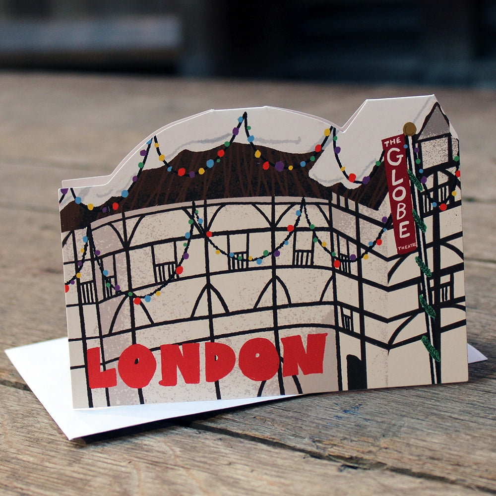 Die cut Christmas card featuring the Globe Theatre adorned with colourful Christmas lights and a snowy thatched roof