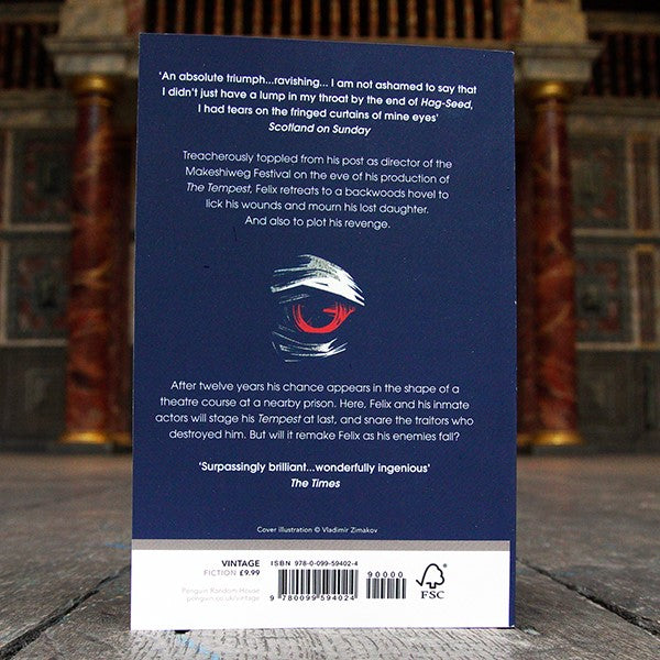Navy blue paperback book with white text and red and white eye graphic