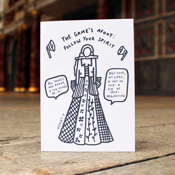 Card with black and white illustration and text on a wooden surface