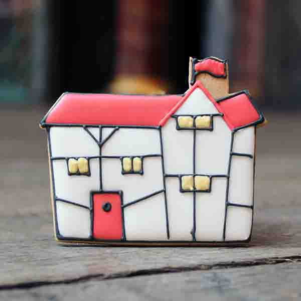 Gingerbread biscuit in the shape of the Globe Theatre, iced with white and red icing