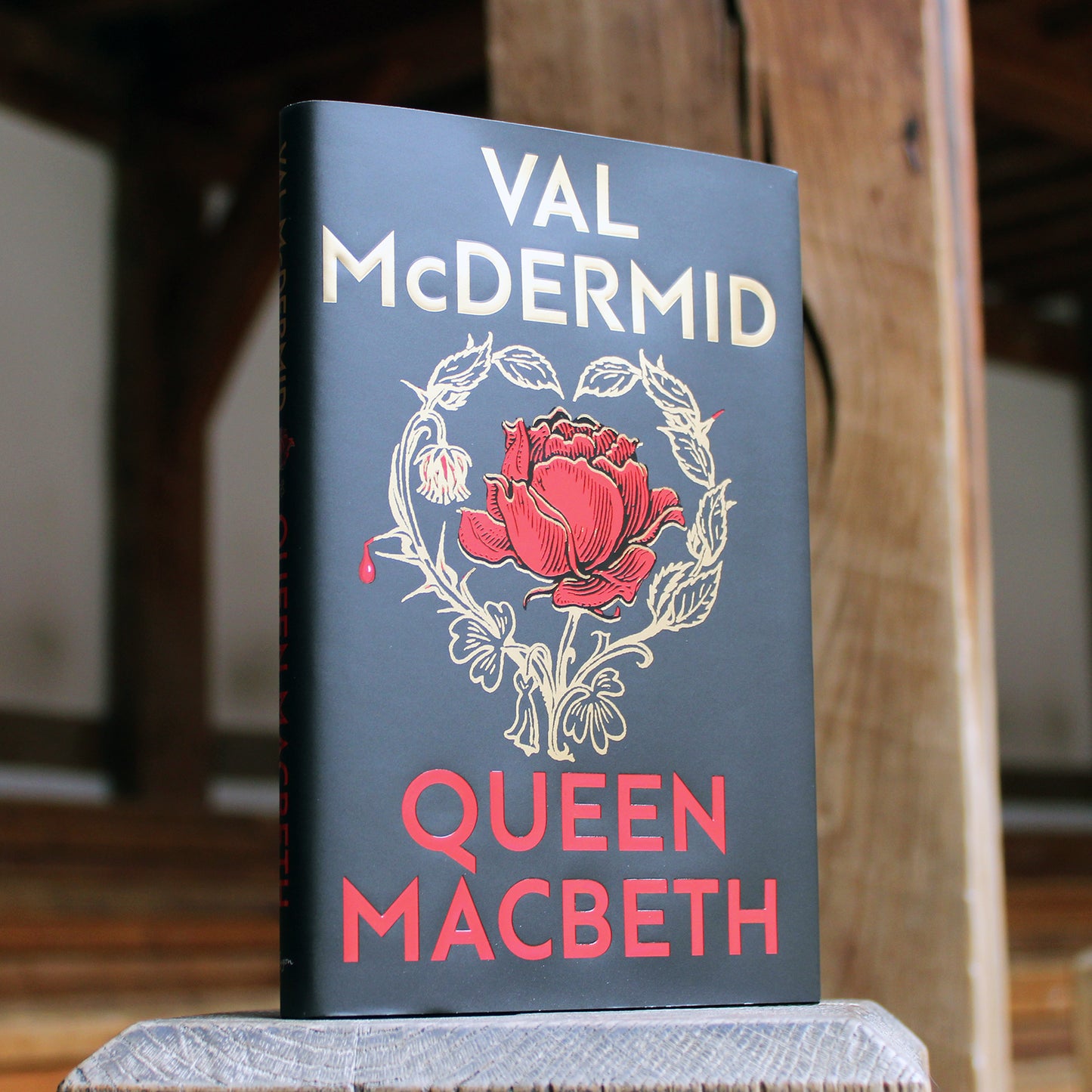 Hardback book with a black cover printed with a gold and red rose.