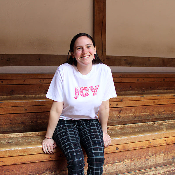 
                  
                    Plain white unisex tshirt with bold red text across the chest depicting JOY
                  
                