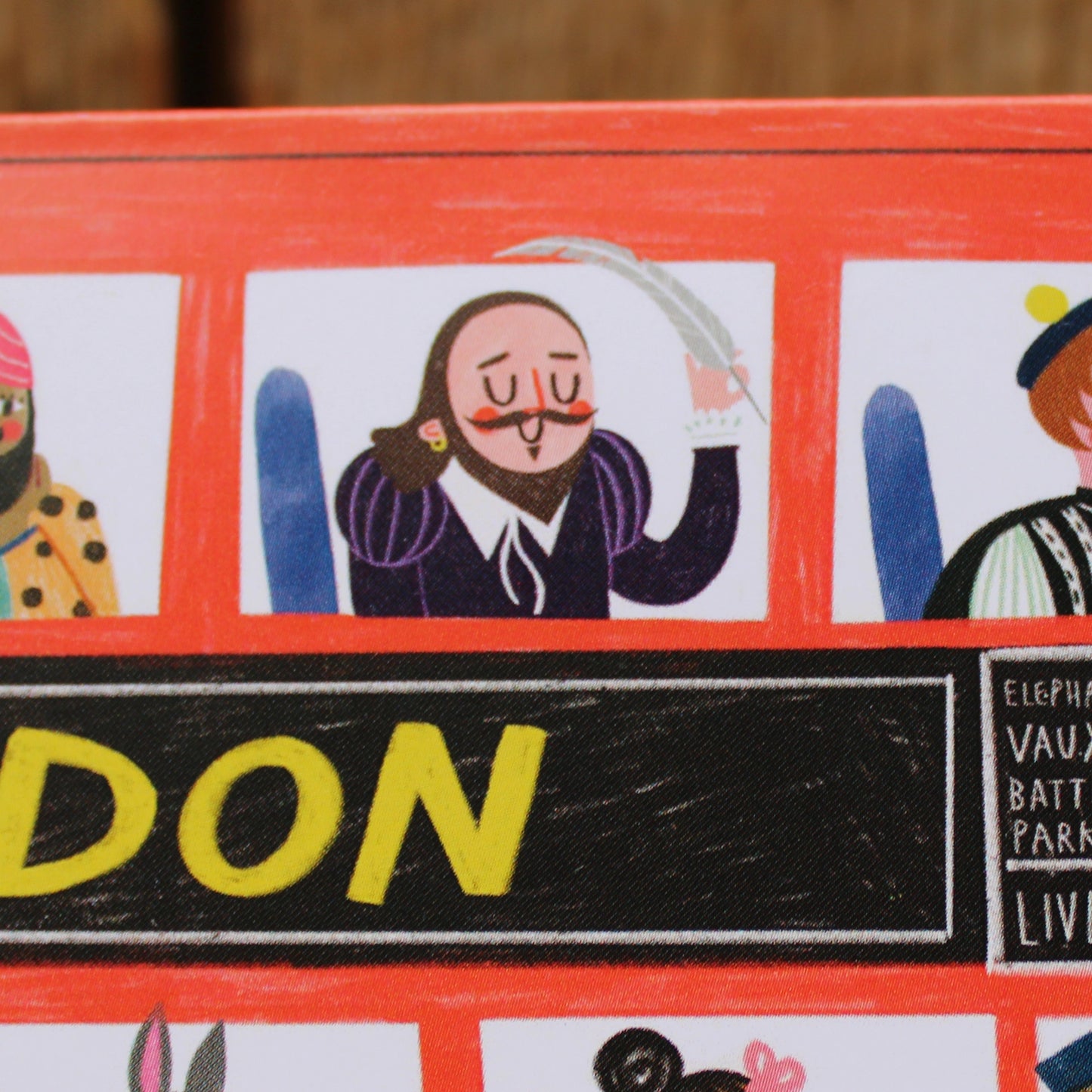 Greetings card shaped like a red London bus with various characters at the windows