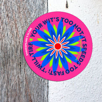 Circular sticker with colorful design and text on a textured surface