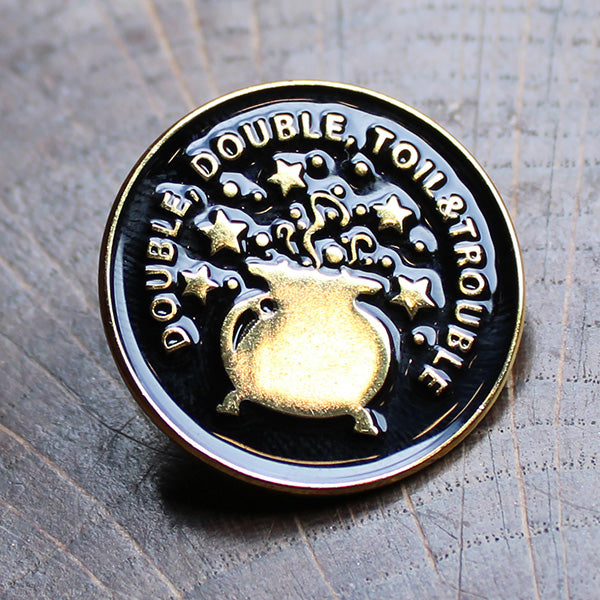 Black and gold coloured round pin badge