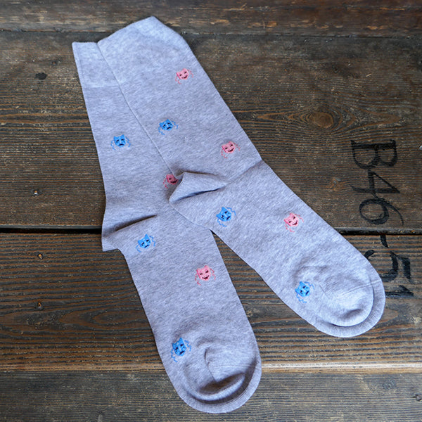 
                      
                        Light grey socks with a repeating pattern of theatre masks in blue and pink
                      
                    