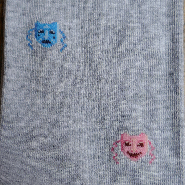 
                      
                        Light grey socks with a repeating pattern of theatre masks in blue and pink
                      
                    