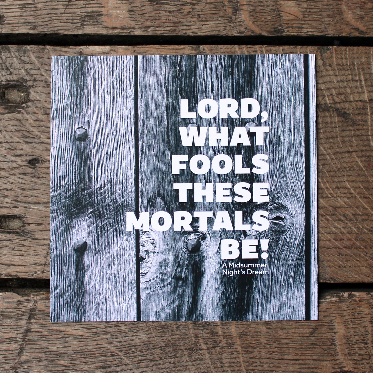 Square print of grey wood-grain with a quote in white lettering over the top
