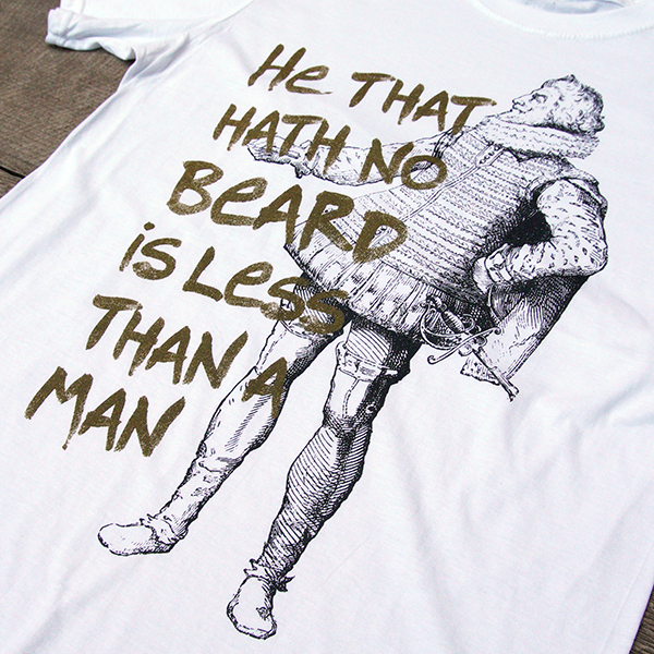 
                  
                    White t-shirt with gold graphic text and black and white historical image of man with a beard
                  
                