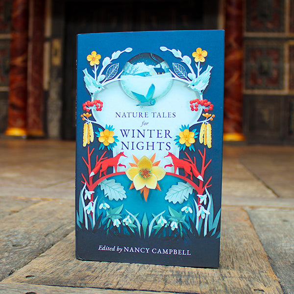 Book titled 'Nature Tales for Winter Nights' by Nancy Campbell on a wooden surface with a blurred background.